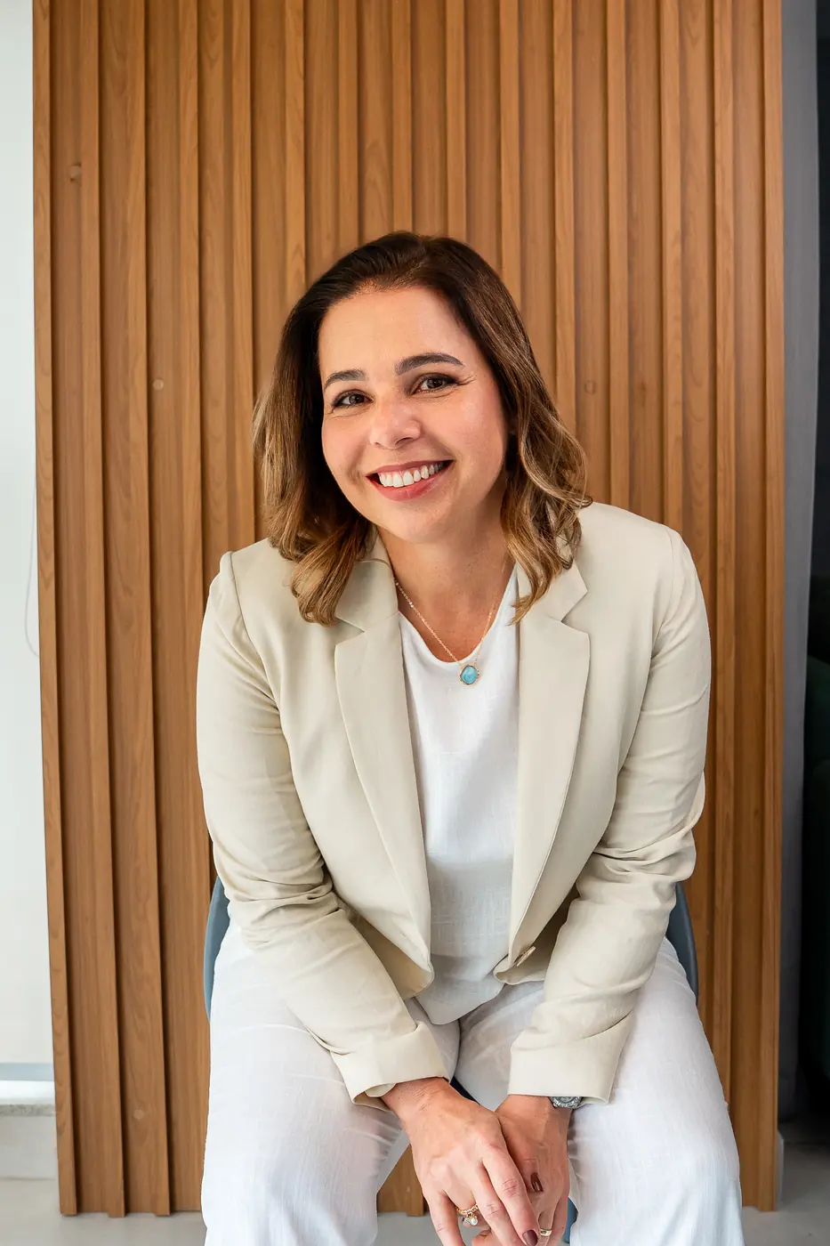 Dra. Elaine Farah de blazer bege, sorrindo, em retrato corporativo